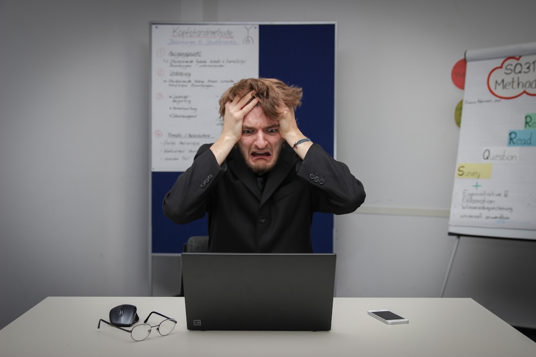 Stressed trader making emotional decisions at computer screen showing Forex charts